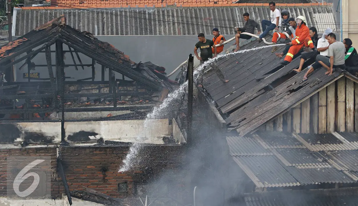 Petugas bersama warga berusaha memadamkan api yang membakar pemukiman penduduk di Jalan Gelora IX A, Palmerah, Jakarta, Kamis (4/8). Api yang diduga berasal dari arus pendek itu membakar 8 rumah. (Liputan6.com/Immanuel Antonius)