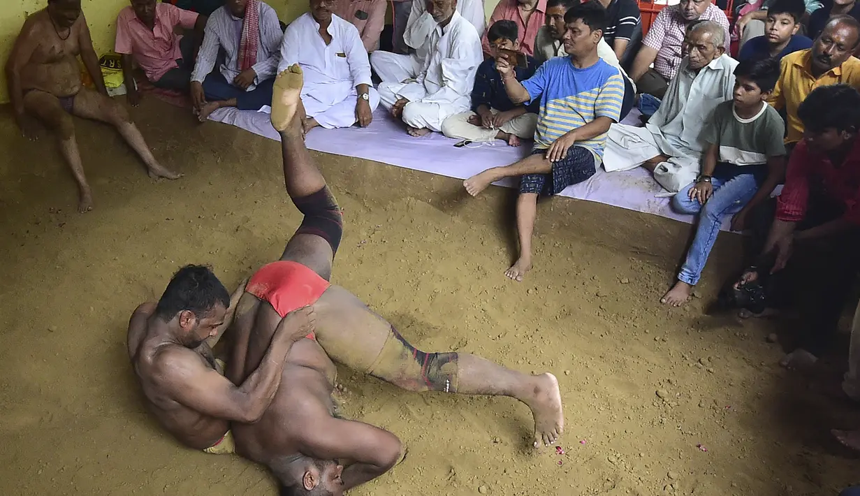 Dua pegulat bertarung dalam pertandingan gulat tradisional di Prayagraj pada 21 Agustus 2023. (AFP/Sanjay Kanojia)