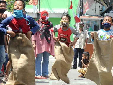 Anak-anak mengikuti lomba balap karung saat acara kegiatan tujuh belas Agustus di Cinere, Depok, Senin (17/8/2020). Warga di sejumlah kampung di wilayah Jabodetabek tetap melakukan beragam kegiatan lomba memperingati HUT ke-75 RI dengan menerapkan protokol kesehatan. (merdeka.com/Arie Basuki)