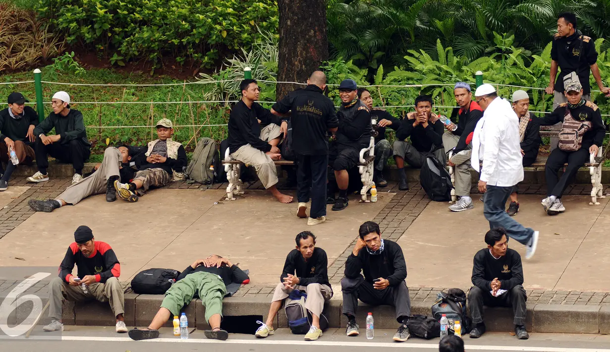 Massa aksi damai beristirahat dan tidur di pinggir Jalan Merdeka Barat, Jakarta, Jumat (4/11). Massa melakukan aksi di depan Istana Negara menuntut penegakan hukum kasus dugaan penistaan agama. (Liputan6.com/Helmi Fithriansyah)