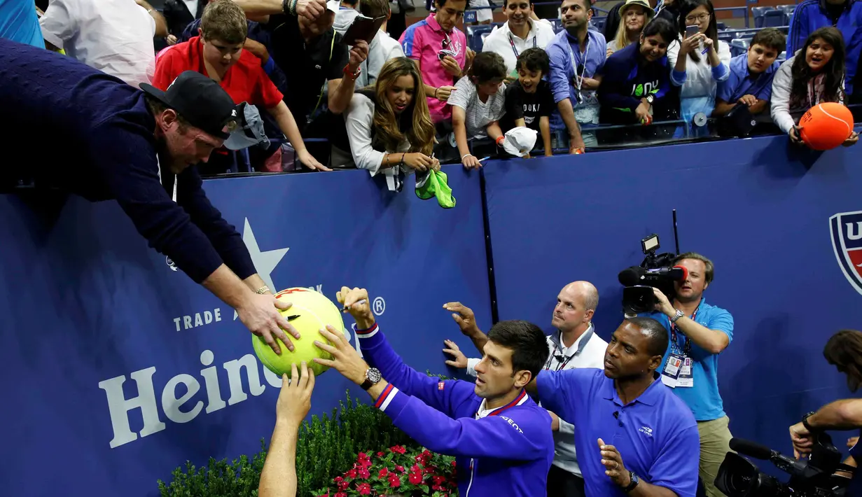 Novak Djokovic memberikan tanda tangan kepada penggemarnya setelah menjuarai AS Terbuka 2015 di lapangan Stadion Arthur Ashe, Senin (14/8/2015) pagi WIB. (Reuters/Lucas Jackson)
