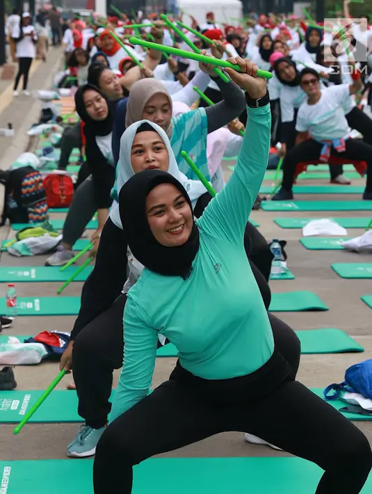 Peserta memainkan stik hijau saat mengikuti Andalan Freshtival Special Kartini Day di GBK Plaza Selatan Senayan, Jakarta, Minggu (21/4). Acara yang diikuti oleh ratusan perempuan tersebut diadakan dalam rangka memeringati Hari Kartini. (Liputan6.com/Immanuel Antonius)