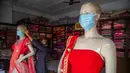 Seorang karyawan toko mengenakan masker wajah pada manekin di Gauhati, India, Rabu (9/6/2021). India melonggarkan sebagian pembatasan untuk mengekang penyebaran virus corona COVID-19. (AP Photo/Anupam Nath)
