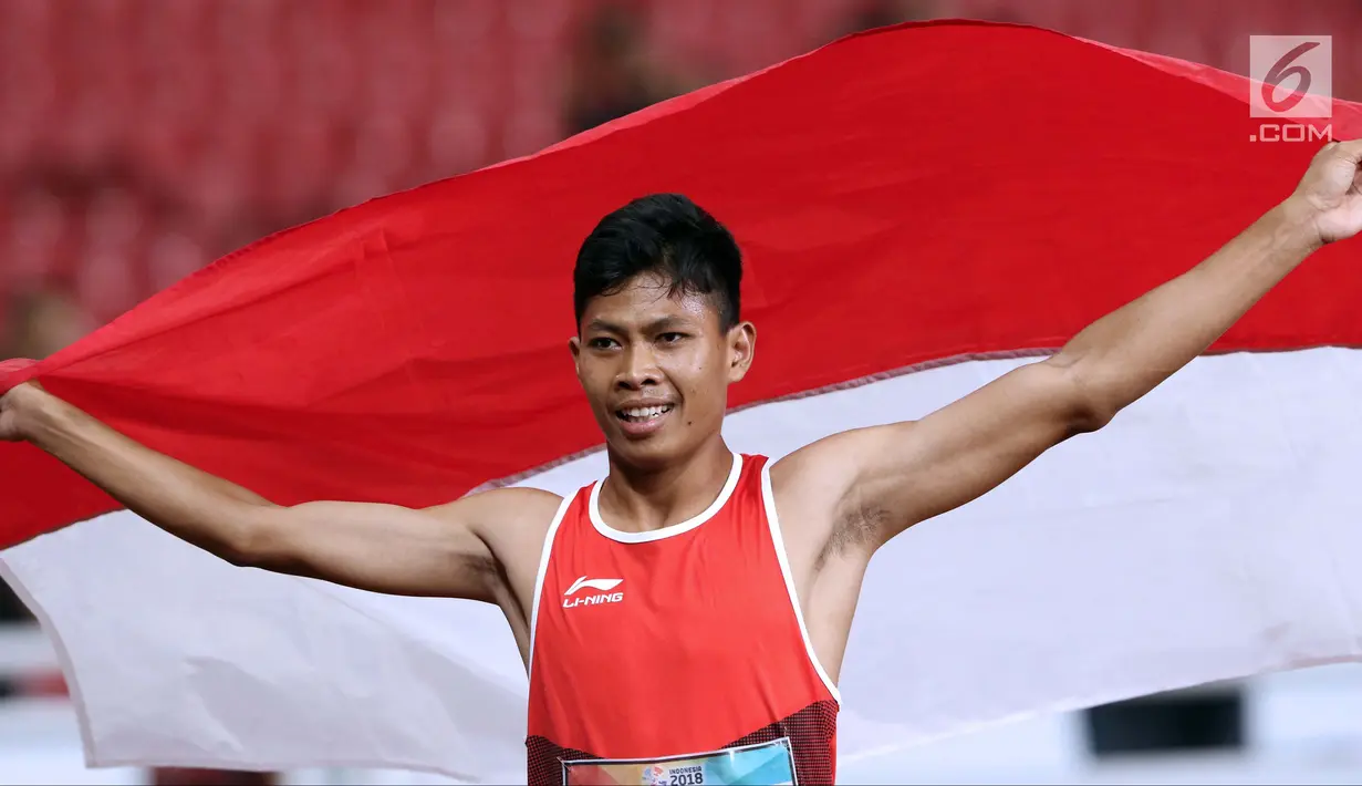 Atlet para-atletik Indonesia, Sapto Yogo Purnomo merayakan kemenangan lari nomor 100 meter T37 pria yang  digelar di Stadion GBK, Jakarta, Selasa (9/10). Ini menjadi medali emas kedua Sapto di Asian Para Games 2018. (Liputan6.com/Helmi Fithriansyah)