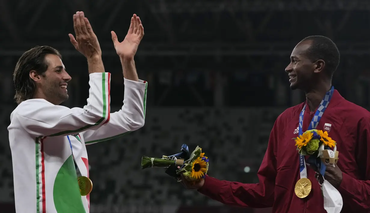 Peraih medali emas bersama Mutaz Barshim (kanan) dari Qatar dan Gianmarco Tamberi dari Italia merayakan di podium setelah final lompat tinggi putra pada Olimpiade Tokyo 2020 di Tokyo, Jepang, Senin (2/8/2021). Barshim dan Tamberi sama-sama tampil tanpa kegagalan. (AP Photo/Francisco Seco)