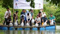 Pj Gubernur Sulsel Bahtiar Baharuddin tebar bibit ikan nila (Liputan6.com/Istimewa)