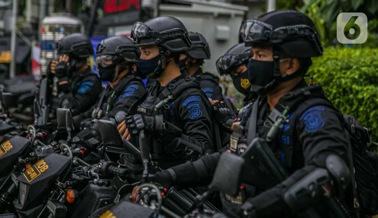 Sejumlah anggota satuan Brimob bersiaga di kawasan Bundaran HI, Jakarta, Kamis (31/12/2020). Dalam pengamanan malam tahun baru, Polda Metro Jaya menurunkan sebanyak 8.139 personel gabungan dan disebar ke beberapa titik sesuai dengan wilayah hukumnya masing-masing (Liputan6.com/Faizal Fanani)