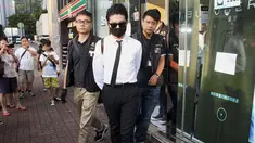 Polisi Hong Kong mengamankan seorang staff saat razia di kantor Uber Inc, Selasa (11/8/2015). Dalam razia ini polisi mengamankan 5 orang yang tertangkap basah memberikan jasa pelayanan sebagai sopir taxi dengan kendaraan ilegal. (REUTERS/Apple Daily)