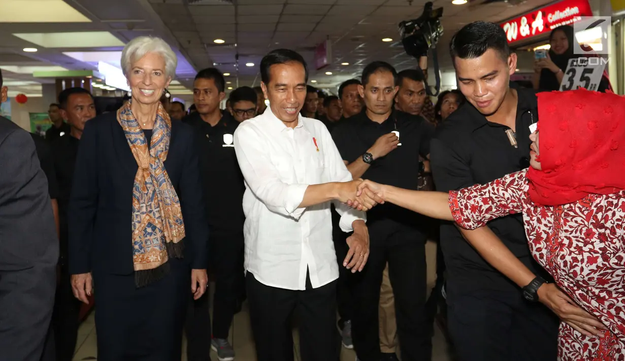 Seorang ibu bersamalan dengan Presiden Jokowi yang tengah mengajak Direktur Pelaksana IMF Christine Lagarde mengunjungi  Pasar Tanah Abang, Senin (26/2). Jokowi dan bos IMF langsung menuju lantai dua untuk mengitari Blok A. (Liputan6.com/Angga Yuniar)