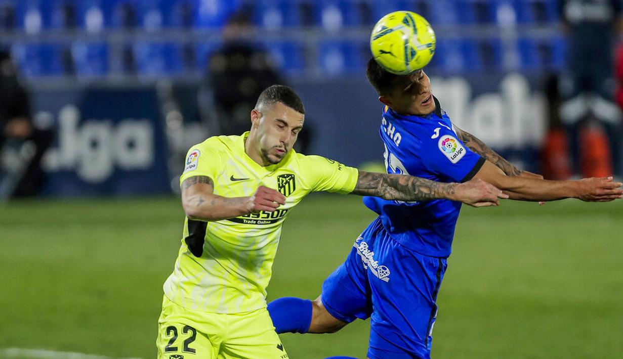 Pemain Atletico Madrid, Mario Hermoso, duel udara dengan pemain Getafe, Cucho Hernandez, pada laga Liga Champions di Stadion Alfonso Perez, Sabtu (13/3/2021). Kedua tim bermain imbang 0-0. (AP/Manu Fernandez)