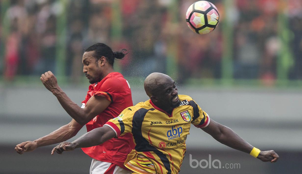 Gelandang Persija, Rohit Chan, duel udara dengan gelandang Mitra Kukar, Mohamed Sissoko, pada laga Liga 1 di Stadion Patriot, Bekasi, Minggu (14/5/2017). Kedua tim bermain imbang 1-1. (Bola.com/Vitalis Yogi Trisna)