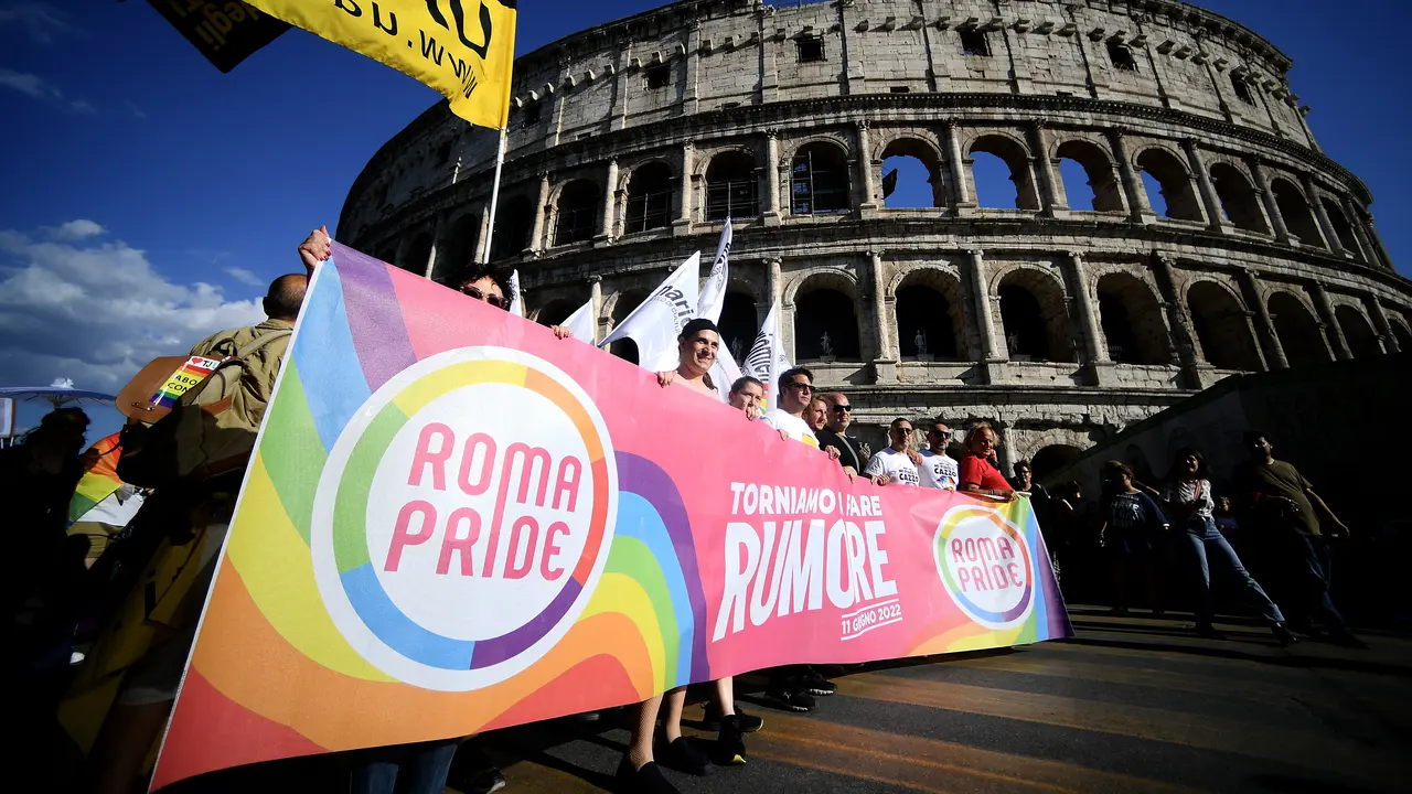 Para peserta memegang spanduk saat mengikuti Pride March tahunan di Roma, Italia pada 11 Juni 2022.