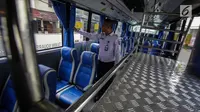Petugas mengecek kondisi dalam bus Transjabodetabek Premium milik Perum PPD saat menunggu calon penumpang di Tamini Square, Jakarta, Kamis (14/12). (Liputan6.com/Faizal Fanani)