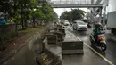 Kendaraan melintas dekat separator busway yang berserakan pascabanjir di Jalan Daan Mogot, Cengkareng, Jakarta, Jumat (3/1/2020). Separator busway tersebut berantakan akibat banjir yang menerjang sejak kemarin. (Liputan6.com/Faizal Fanani)
