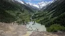 Foto udara menunjukkan puing-puing dan sisa desa Blatten, yang kini terendam sungai Lonza, setelah Gletser Birch yang besar runtuh dan tanah longsor besar-besaran yang melemparkan berton-ton batu, es, dan pohon cemara ke lereng gunung dan ke lembah di bawahnya di Blatten pada tanggal 31 Mei 2025. (Fabrice COFFRINI/AFP)