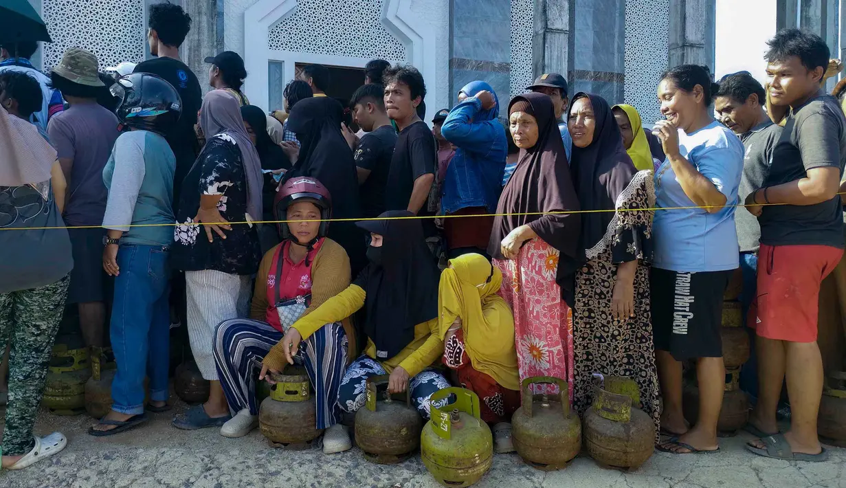Di sisi lain, warga rela antre untuk membeli LPG 3 kg di tengah kelangkaaan pasokan Bahan Bakar Minyak dan Gas akibat terputusnya beberapa jalan penghubung akibat banjir bandang dan tanah longsor di sejumlah wilayah Sumatra Utara. Tampak dalam foto, warga desa mengantre untuk membeli tabung gas di Pandan, Tapanuli Tengah, Provinsi Sumatra Utara, pada Rabu 3 Desember 2025. (DAMAI MENDROFA/AFP)