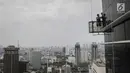 Pekerja tanpa helm keselamatan beraktivitas di gedung bertingkat di Jakarta, Rabu (15/11). Banyak kejadian kecelakaan kerja di ketinggian disebabkan karena minimnya pengetahuan dasar mengenai keselamatan kerja di ketinggian. (Liputan6.com/Faizal Fanani)
