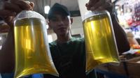 Pedagang menunjukkan plastik berisi minyak goreng curah di Pasar Senen, Jakarta, Selasa (31/5/2022). Kementerian Perindustrian mencabut subsidi minyak goreng curah kepada pelaku usaha mulai Selasa (31/5/2022). (Liputan6.com/Herman Zakharia)