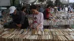 Seorang wanita mencari buku yang di dijual selama pameran buku bekas di Hanoi, Vietnam (26/10).( AFP Photo/Hoang Dinh Nam)