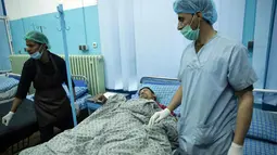 Dokter mengecek kondisi pria korban serangan bom bunuh diri di rumah sakit Wazir Akbar Khan di Kabul, Afghanistan (31/10). Dilaporkan sedikitnya 4 Orang tewas dan puluhan lainnya luka-luka akibat serangan tersebut. (AP Photo/Massoud Hossaini)