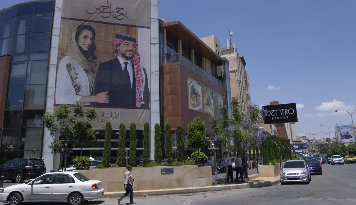 Sebuah poster bergambar Putra Mahkota Yordania Hussein dan tunangannya, arsitek Saudi Rajwa Alseif digantung di depan sebuah gedung di Amman, Yordania, Selasa, 30 Mei 2023. (AP Photo/Nasser Nasser)