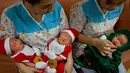 Suster memegang bayi yang baru lahir di Paolo memorial hospital di Bangkok, Thailand (21/12). Menyambut Hari Natal bayi-bayi di rumah sakit ini diberi busana Natal. (AP Photo / Gemunu Amarasinghe)