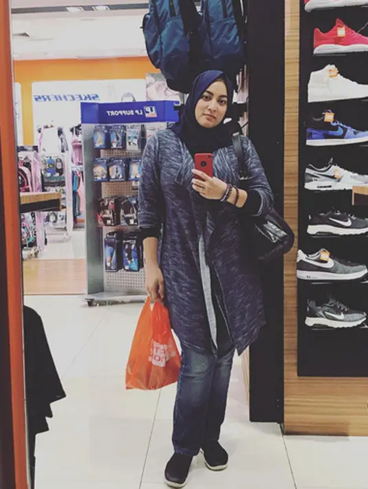 Seperti yang ada di dalam foto ini, Jane terlihat sedang berada di sebuah tempat perbelanjaan. Mengenakan hijab biru dan tampil casual, Jane sedang asik mirror selfie sambil membawa kantong belanjaan. (Instagram/jshaz26)