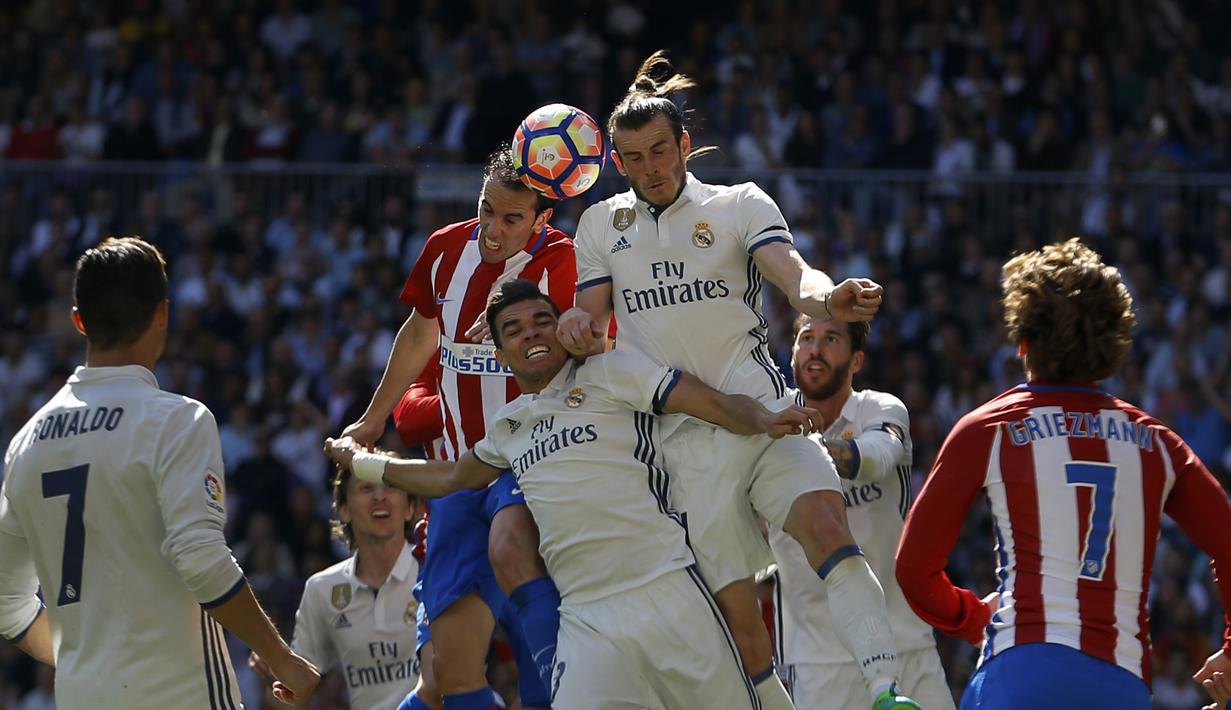 Pemain Real Madrid Real Madrid, Pepe (tengah) saat berebut bola dengan pemain Atletico Madrid, Diego Godin pada laga La Liga di Santiago Bernabeu stadium, Madrid, (8/4/2017). Real Madrid bermain Imbang 1-1 dengan Atletico.(AP/Daniel Ochoa de Olza)