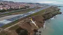 Sebuah pesawat dari maskapai Pegasus Airlines nyaris terperosok ke dalam laut di bandara Trabzon, Turki, Minggu (14/1). Peristiwa tersebut terjadi setelah pesawat mendarat dan  tergelincir dari landasan pacu. (DOGAN NEWS AGENCY/AFP)