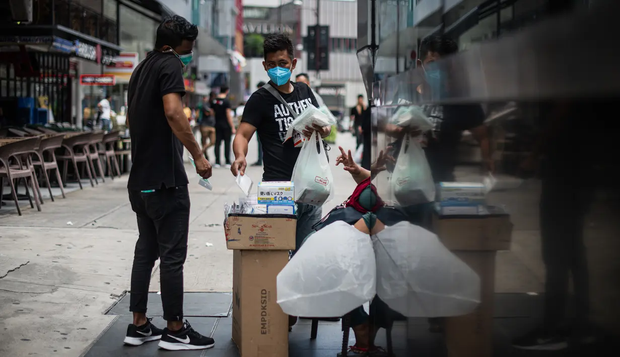 Dua pria membeli masker di tengah kekhawatiran akan penyebaran virus corona COVID-19, di Kuala Lumpur, Malaysia, Kamis, (13/2/2020). (AFP/Mohd Rasfan)