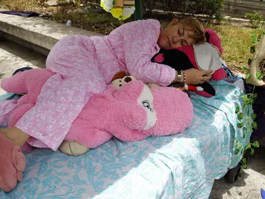 Seorang perempuan berpura-pura tertidur saat perayaan Hari Kemalasan Sedunia atau World Day of Laziness di Itagui, Kolombia, pada 20 Agustus 2023. (Fredy BUILES / AFP)