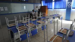 Guru berbincang dengan seorang siswa di ruang kelas yang kosong di Mts Annajah, Petukangan, Jakarta, Senin (5/8/2019). Masih padamnya listrik di sejumlah kawasan Jakarta membuat kegiatan belajar mengajar terganggu hingga memaksa pihak sekolah memulangkan siswa lebih awal. (merdeka.com/Arie Basuki)