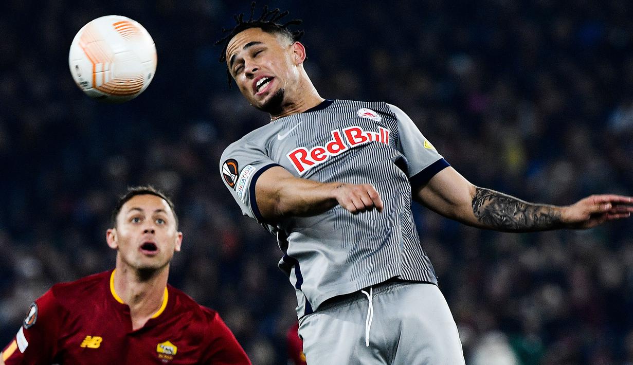 Pemain RB Salzburg, Noah Okafor menyundul bola pada laga leg kedua play off UEFA Europa League melawan AS Roma di Olympic Stadium, Roma, 23 Februari 2023. Okafor tampil menjanjikan pada musim lalu sebelum dirinya mengalami patah tulang metatarsal yang membuat musimnya berakhir pada April. Meskipun begitu, ia tercatat berhasil mencetak mencetak 10 gol dalam 32 penampilan di semua kompetisi. RB Salzburg diketahui menuntut sekitar 25 juta pounds untuk talenta muda mereka.  (AFP/Filippo Monteforte)