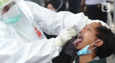 Paramedis mengambil sampel penumpang KRL Commuter Line saat tes swab di Stasiun Bojonggeder, Jawa Barat, Senin (11/05/2020).  Pemkab Bogor  melakukan tes swab  dan rapid test bagi penumpang KRL Commuter Line  dilakukan secara massal. (merdeka.com/Arie Basuki)