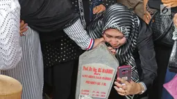 Seorang wanita berswafoto dengan batu nisan Presiden ketiga BJ Habibie di Taman Makam Pahlawan Nasional Kalibata, Jakarta, Kamis (12/9/2019). Selain berdoa, tidak sedikit juga warga  mengabadikan dengan kamera ponsel. (Liputan6.com/Herman Zakharia)