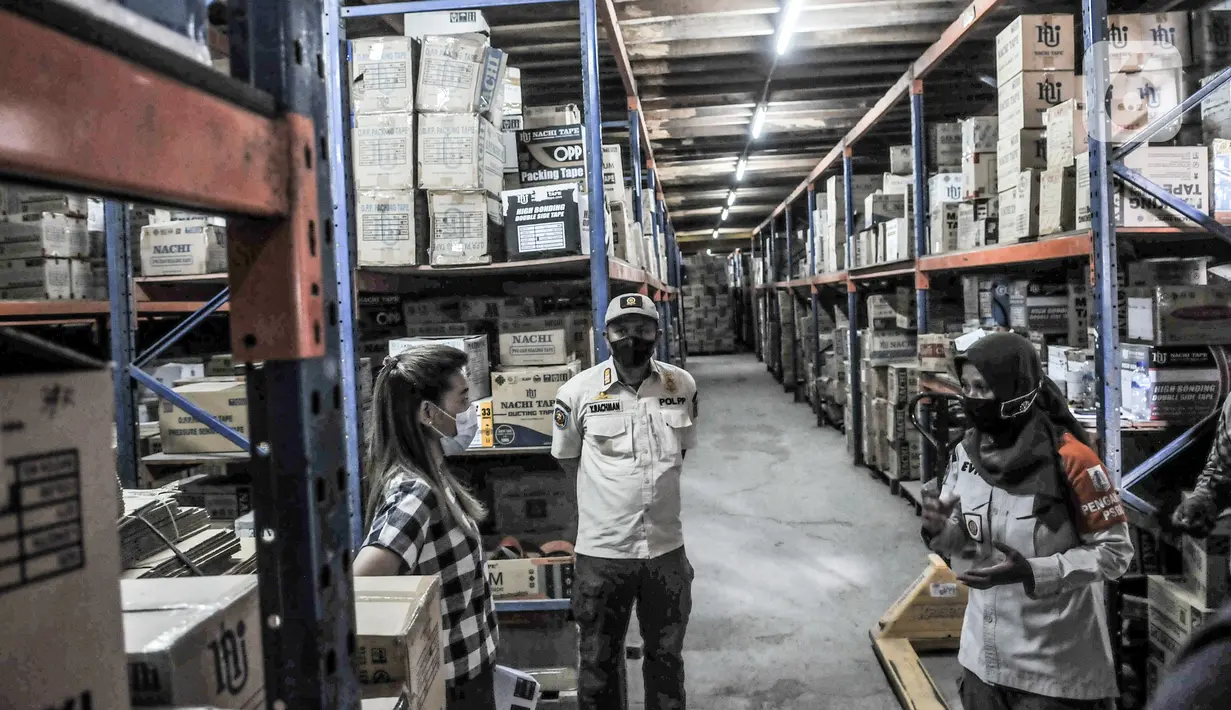 Petugas Satpol PP Kecamatan Tanjung Priok meninjau gudang penyimpanan barang di salah satu perkantoran kawasan Sunter, Jakarta, Rabu (10/2/2021). Sidak tersebut merupakan bagian dari penerapan Pemberlakuan Pembatasan Kegiatan Masyarakat (PPKM) skala mikro. (merdeka.com/Iqbal s Nugroho)