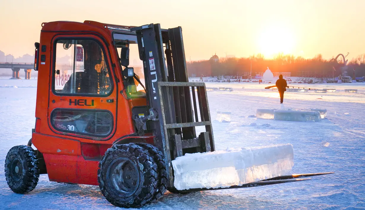 Pekerja menggunakan alat berat mengumpulkan es dari Sungai Songhua di Harbin, ibu kota Provinsi Heilongjiang, China timur laut (7/12/2020). Bongkahan es yang dikumpulkan dari Sungai Songhua yang membeku itu akan digunakan sebagai dekorasi kota tersebut. (Xinhua/Wang Song)
