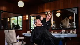 Dalia Antunes (44) yang berprofesi sebagai tukang cukur profesional selama hampir 30 tahun bekerja di Oliveira Barbershop di Lisbon, Portugal, Sabtu (3/3). (AFP PHOTO/PATRICIA DE MELO MOREIRA)