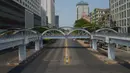 Sebuah mobil melintasi jalanan yang kosong di pusat Kota Yangon, Myanmar, Rabu (24/3/2021. Demonstran antikudeta mencoba taktik baru yang mereka sebut pemogokan 'diam', menyerukan orang-orang untuk tinggal di rumah dan menutup bisnis. (AP Photo)