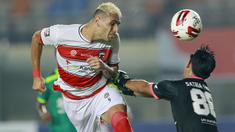 Bek Madura United, Jaimerson Da Silva Xavier (kiri) duel udara dengan kiper Persebaya Surabaya, Satria Tama, dalam pertandingan Babak Penyisihan Piala Menpora 2021 Grup C di Stadion Si Jalak Harupat, Bandung, Minggu (28/3/2021). (Foto: Bola.com/M Iqbal Ichsan)