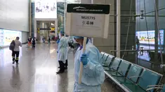 Petugas mengangkat papan untuk memandu kerabat penumpang pesawat China Eastern Airlines setelah gagal tiba di Bandara Internasional Baiyun, Guangzhou, selatan China, Senin (21/3/2022). Pesawat Boeing 737 milik China Eastern Airlines jatuh di Daerah Otonomi Guangxi pada Senin sore. (STR/AFP)