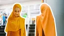 Avi memilih tampil cerah dengan outfitnya. Mengenakan kebaya panjang orange memiliki aksen slit warna orange senada dengan kerudung panjang polos. [@official_amteam]