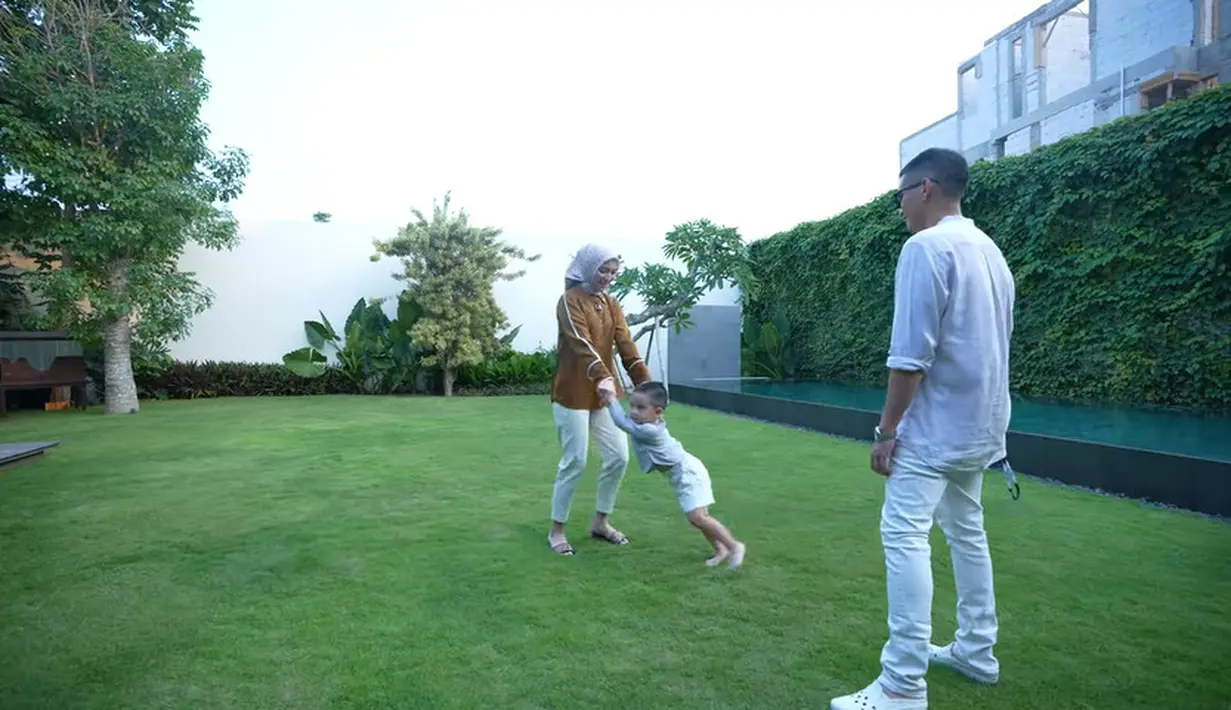 <p>Tidak hanya depan rumah yang memiliki halaman asri, tapi juga di halaman belakang. Banyak menggunakan dinding kaca, agar sinar matahari bisa langsung masuk untuk penerangan di siang hari. Halaman sangat luas dan sangat asri. [Youtube/CikyCitraRezky]</p>