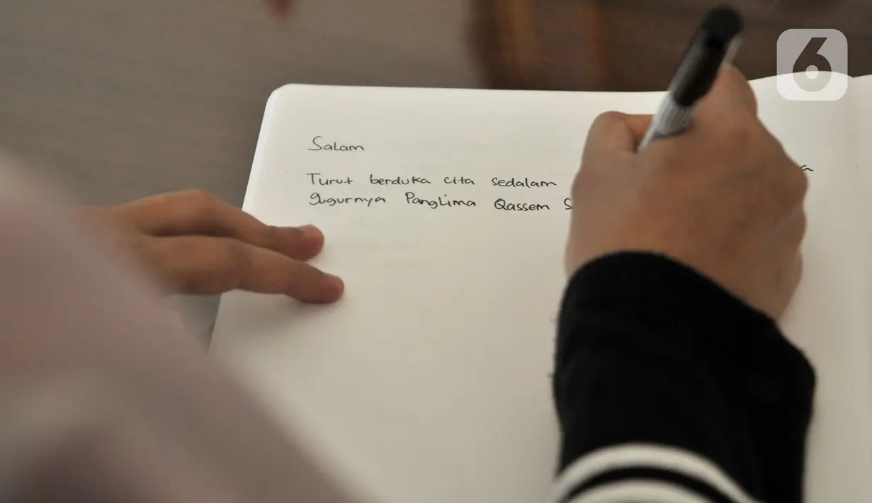 Warga menuliskan memo belasungkawa atas wafatnya Panglima Garda Revolusi Iran Jenderal Qasem Soleimani di Kedutaan Besar Iran, Jakarta, Selasa (7/1/2020). (merdeka.com/Iqbal S. Nugroho)