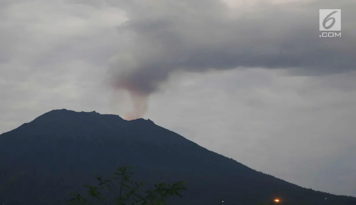 Asap yang disemburkan dari kawah Gunung Agung terlihat di Karang Asem, Bali (30/11). H+6 pasca erupsi, warna merah di puncak Gunung Agung mulai tampak samar, berbeda dengan beberapa hari sebelumnya. (Liputan6.com/Immanuel Antonius)