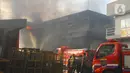 Petugas pemadam kebakaran berusaha memadamkan api yang membakar Gudang JNE Express di Jalan Pekapuran Raya, Depok, pada Senin (12/9/2022).  Awalnya api kecil datang dari sebelah barat Gudang JNE, kemudian menyambar hingga menghanguskan gedung yang lain. (Liputan6.com/Herman Zakharia)
