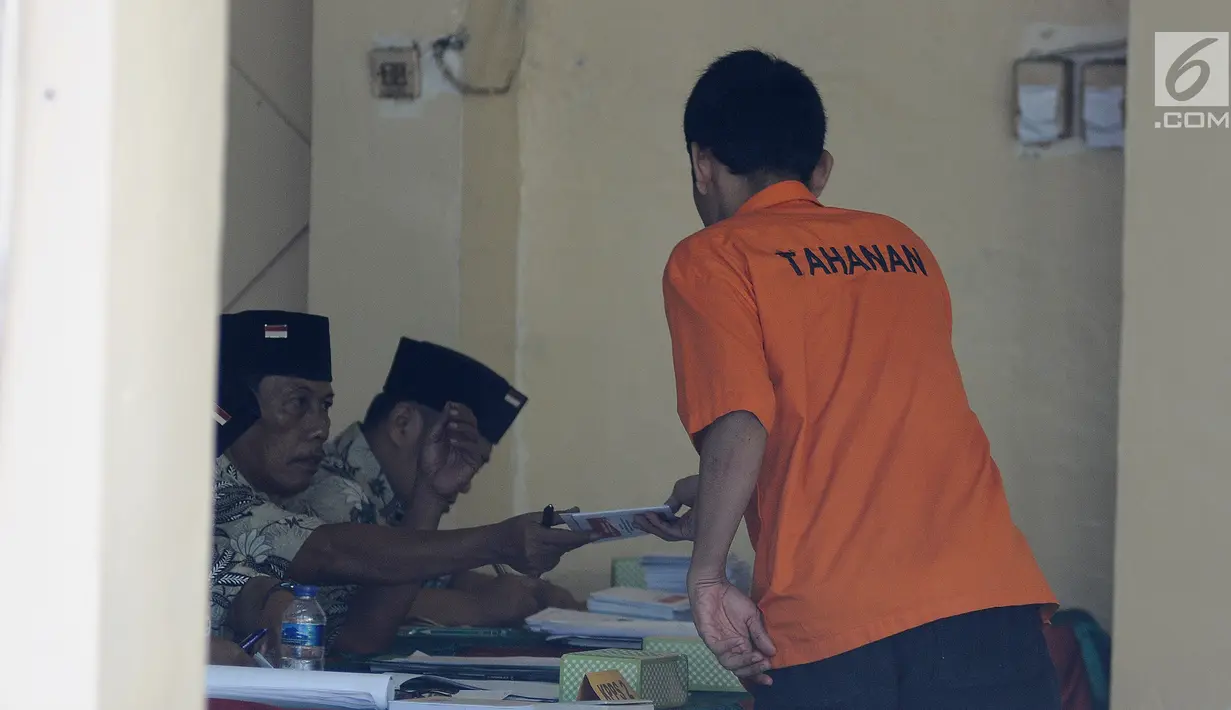 Tahanan mengambil surat suara saat akan mencoblos di TPS 15 Rutan Polda Metro Jaya, Jakarta, Rabu (17/4). Anggota kepolisian yang bertugas dilarang untuk memasuki lokasi TPS yang telah disediakan. (Liputan6.com/Herman Zakharia)