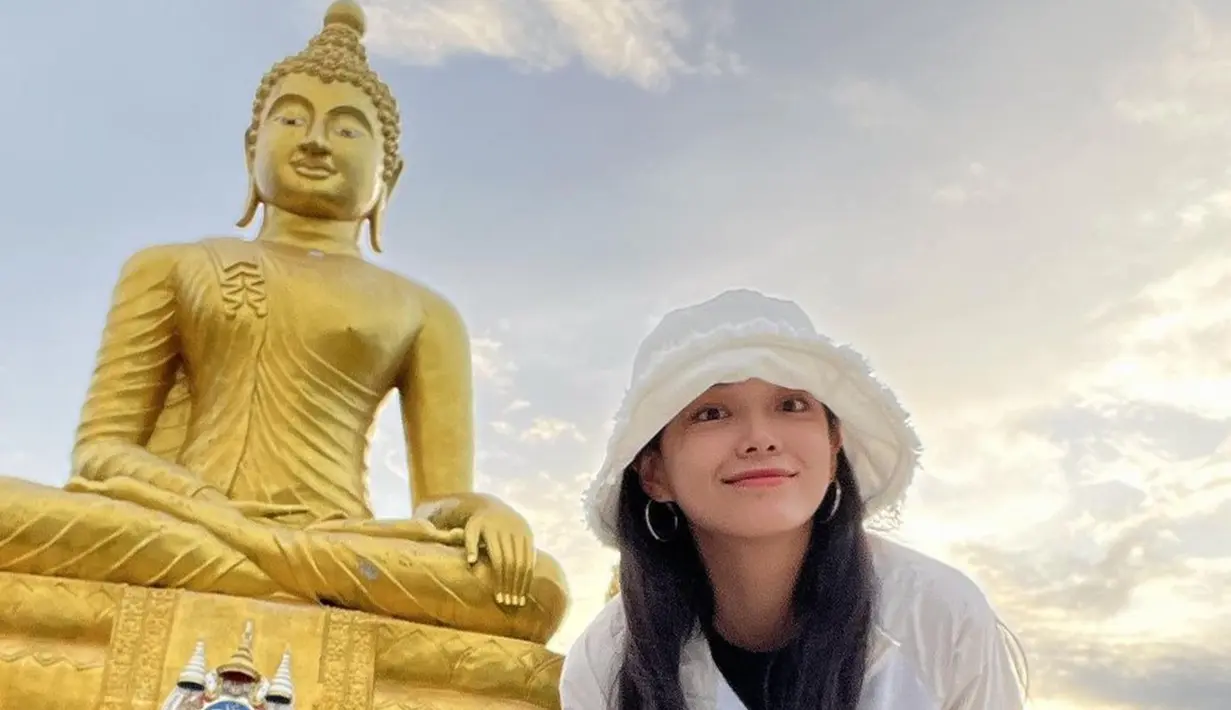 Selain menikmati liburan di daerah pantai, Kim Se Jeong juga tampak mengunjungi tempat wisata religi. Mantan member girlband Gugudan ini juga memamerkan senyum semringah saat berfoto di depan patung Budha berukuran besar. Suasana sore yang cerah semakin membuat indah harinya. (Liputan6.com/IG/@clean_0828)