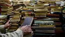 Jose Alberto Gutierrez memeriksa buku koleksinya yang ada di perpustakaan rumahnya di Bogota, 18 Mei 2017. Koleksi buku Gutierrez beragam, mulai dari buku-buku pelajaran hingga novel karya maestro Kolombia, gabriel Garcia Marquez. (GUILLERMO LEGARIA/AFP)