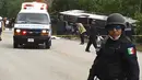 Petugas kepolisian berjaga di lokasi kecelakaan sebuah bus wisata yang terbalik di Quintana Roo, Meksiko, Selasa (19/12). Pihak berwenang belum mengeluarkan data resmi mengenai kewarganegaraan korban tewas. (Manuel Jesús ORTEGA CANCHE/AFP)